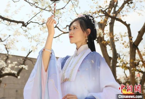 圖為蘭州青年身穿漢服在百年梨園賞景?！「哒?攝