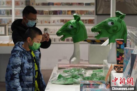 圖為“神馬來了”銅奔馬頭套吸引參觀者駐足?！【琶赖┰?攝