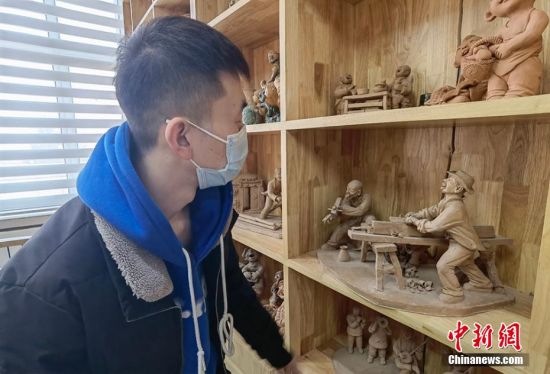 圖為學(xué)生欣賞泥塑作品。 劉玉桃 攝