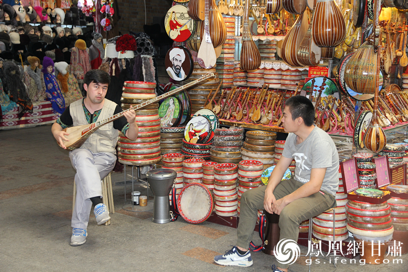 烏魯木齊二道橋巴扎內(nèi)，店主正在向客人展示樂器。楊文遠 攝