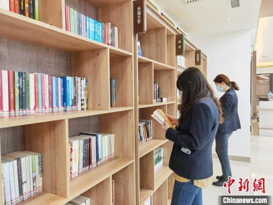 圖為在甘肅公航旅建設(shè)集團(tuán)有限公司的職工書屋，職工挑選書籍?！⌒煅?攝