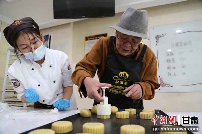 當日，受邀參加活動的臺胞臺屬代表、兩岸婚姻及子女、在甘臺商代表等歡聚一堂。圖為77歲的在甘臺胞潘天鑒制作月餅。九美旦增 攝