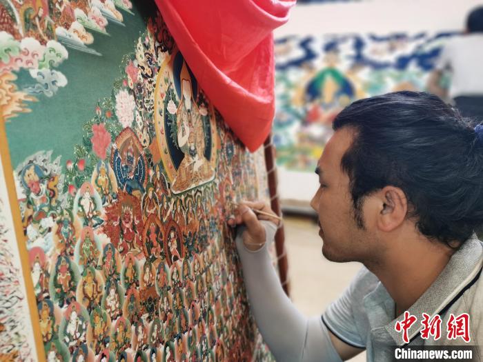 圖為更登才讓的徒弟繪畫唐卡。　張?zhí)砀?攝