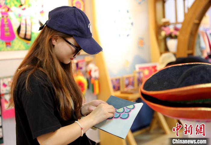 圖為民眾體驗(yàn)國家級非遺項(xiàng)目盤繡技藝?！⊙Φ?攝