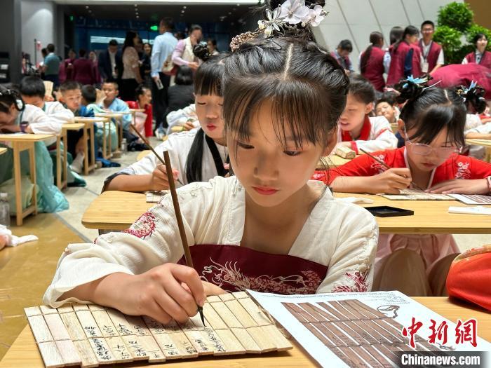 圖為小朋友在甘肅簡(jiǎn)牘博物館練習(xí)書法?！≈行律缬浾?戴文昌 攝