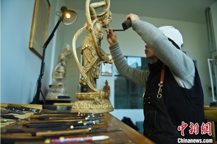 圖為季茂杰進行敦煌元素的木雕創(chuàng)作。李亞龍 攝</p>
<p>