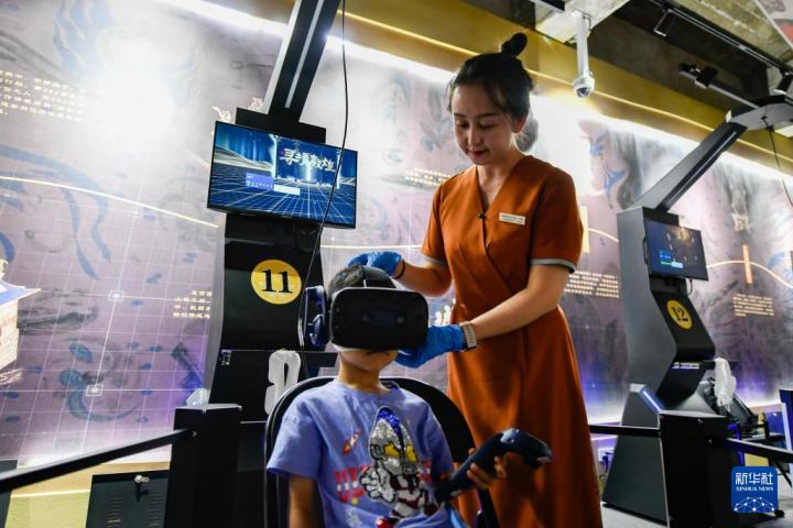 7月22日，敦煌研究院文化弘揚部工作人員引導游客佩戴使用VR設(shè)備。新華社記者 郎兵兵 攝</p>
<p>